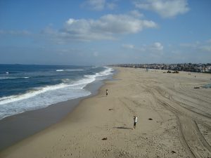 View of Hermosa Beach on a clear day with only a couple people out on the beach.