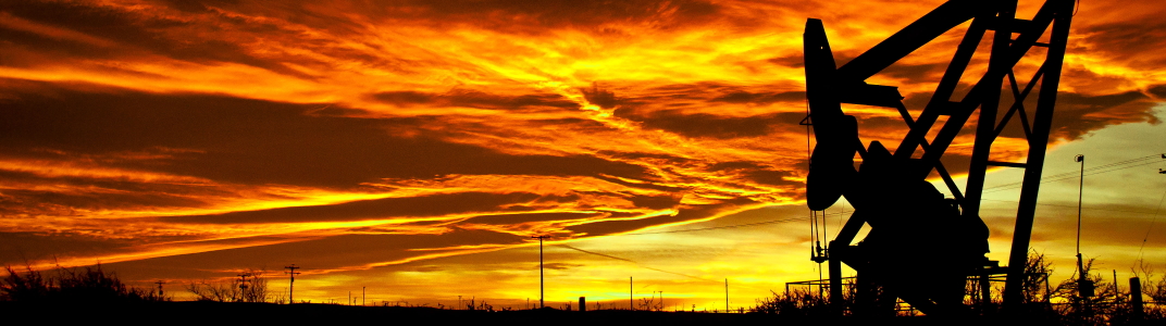 Sunset between rainstorms outside Taft, CA. Red and Orange sky with an oil well silhouette to the front right.