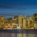 Thousands of lights from the San Francisco skyline reflect on San Francisco Bay.