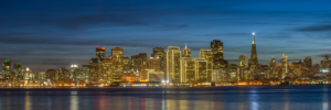 Thousands of lights from the San Francisco skyline reflect on San Francisco Bay.