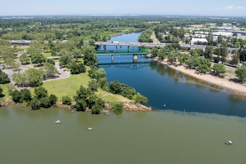 A drone photo shows boats in the Sacramento River near the confluence with the American River — spanned by Interstate 5 — at Discovery Park in Sacramento, California.