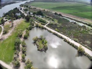 Windmill Cove Resort aerial view of the river to the left and facilities to the left with leach fields in the foreground.